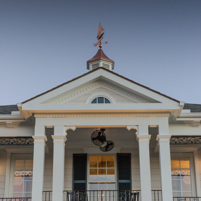 Portico with triangular pediment, columns and cupola at dusk in Haunted Mansion Homage, a custom home by Mike Stevens Homes