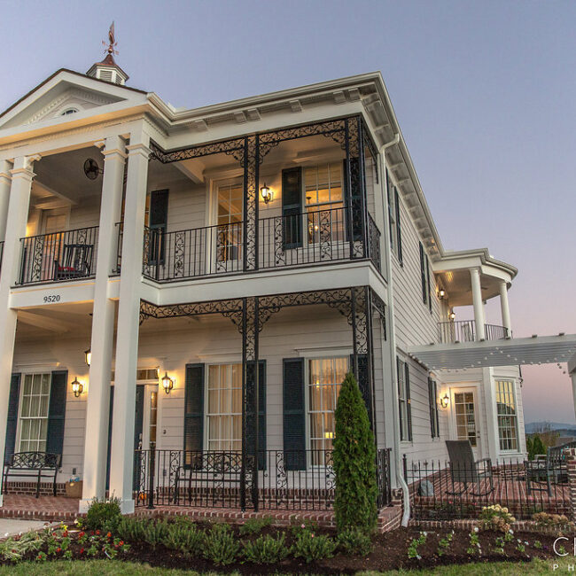 White home with iron balconies and a side wing in Haunted Mansion Homage, a custom home by Mike Stevens Homes