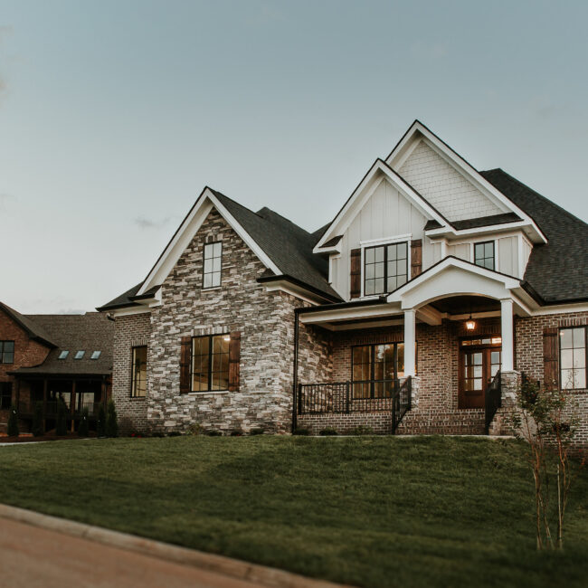 Exterior of stone-and-brick home with gabled entry in Timeless Charm, a custom home by Mike Stevens Homes