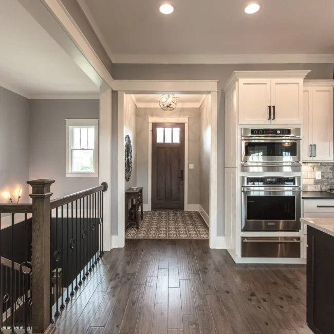 Front entry with dark wood door and hallway runner in Urban Farmhouse, a custom home by Mike Stevens Homes