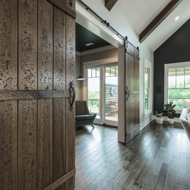 Entry with rustic barn door and gray walls in Urban Farmhouse, a custom home by Mike Stevens Homes