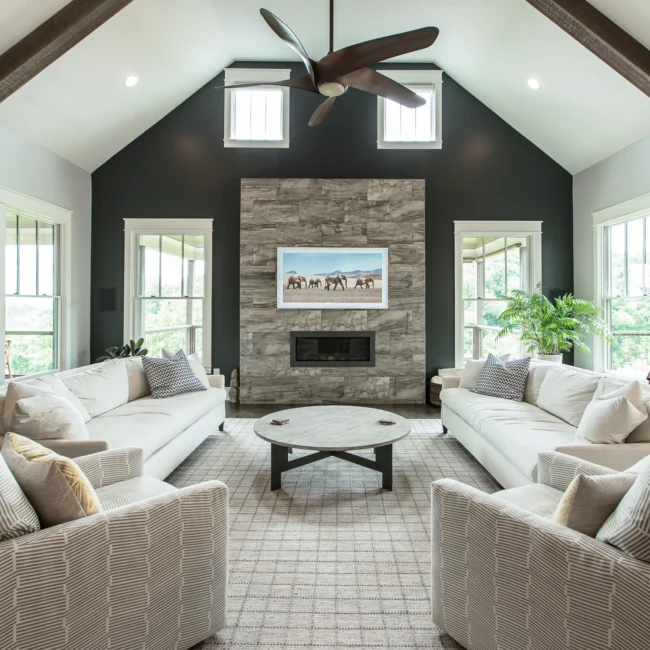 Living room with stone fireplace and dark accent wall in Urban Farmhouse, a custom home by Mike Stevens Homes