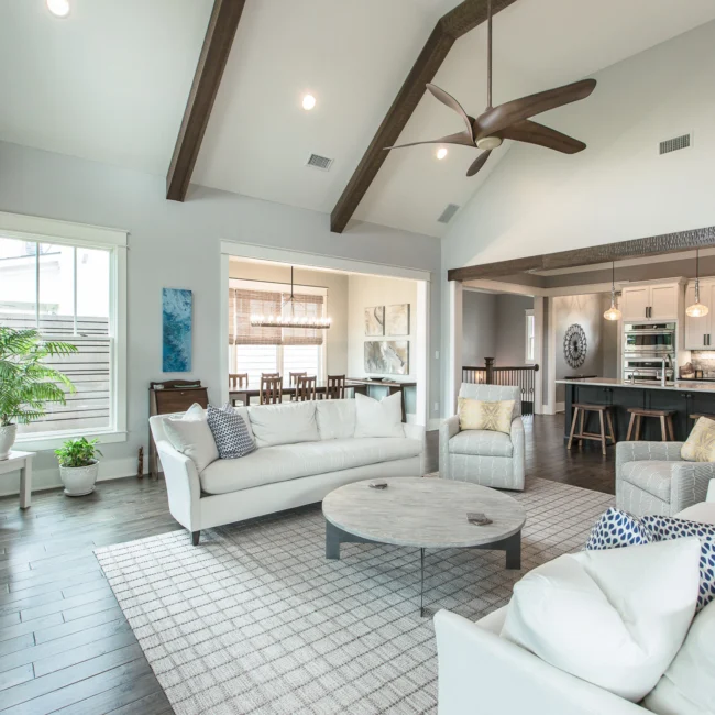 Living room with gray sofa and vaulted ceiling in Urban Farmhouse, a custom home by Mike Stevens Homes