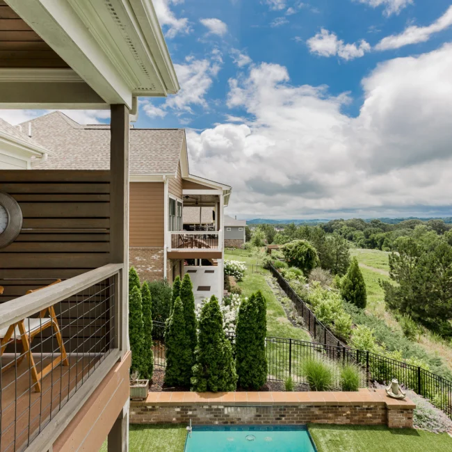 Covered balcony overlooking landscaped yard and pool in Urban Farmhouse, a custom home by Mike Stevens Homes