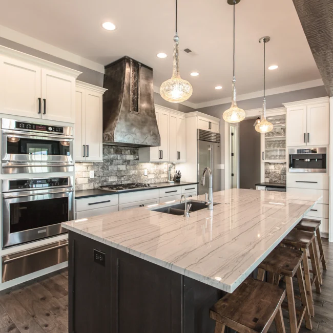 Kitchen with black range hood and pendant lights in Urban Farmhouse, a custom home by Mike Stevens Homes