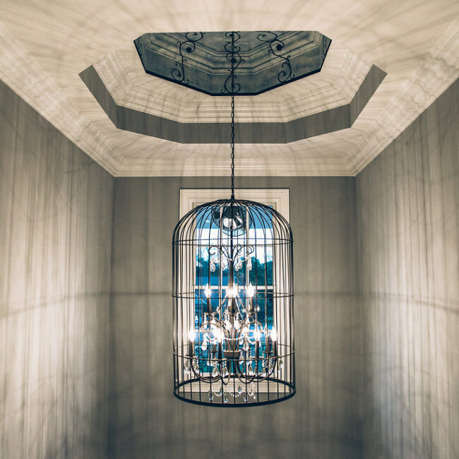 Foyer looking up at octagonal ceiling and birdcage chandelier in Haunted Mansion Homage, a custom home by Mike Stevens Homes