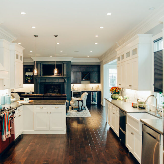 Open kitchen with dark wood floors and white cabinetry in Haunted Mansion Homage, a custom home by Mike Stevens Homes