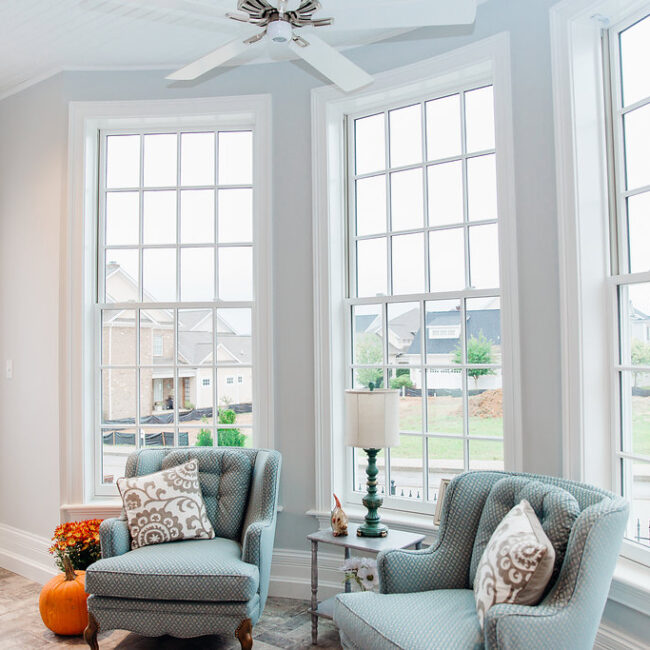 Bay window sitting area with blue-gray chairs and pumpkins in Haunted Mansion Homage, a custom home by Mike Stevens Homes