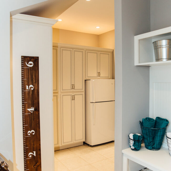 Mudroom with growth chart and white built-in lockers in Haunted Mansion Homage, a custom home by Mike Stevens Homes