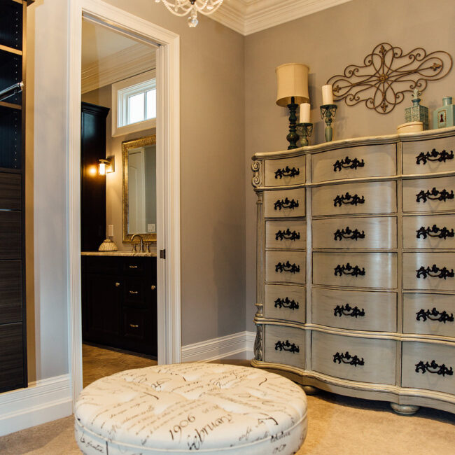 Silver dresser and patterned ottoman in primary suite in Haunted Mansion Homage, a custom home by Mike Stevens Homes