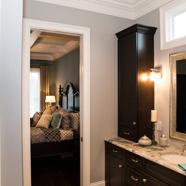 Primary bath with dark cabinetry and view into bedroom in Haunted Mansion Homage, a custom home by Mike Stevens Homes