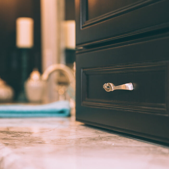 Close-up of dark cabinet pull and marble counter in Haunted Mansion Homage, a custom home by Mike Stevens Homes