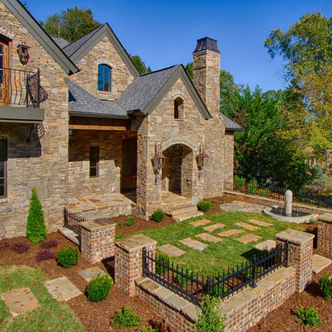 Stone villa facade with stone walkway, garden wall and fountain in European Villa, a custom home by Mike Stevens Homes
