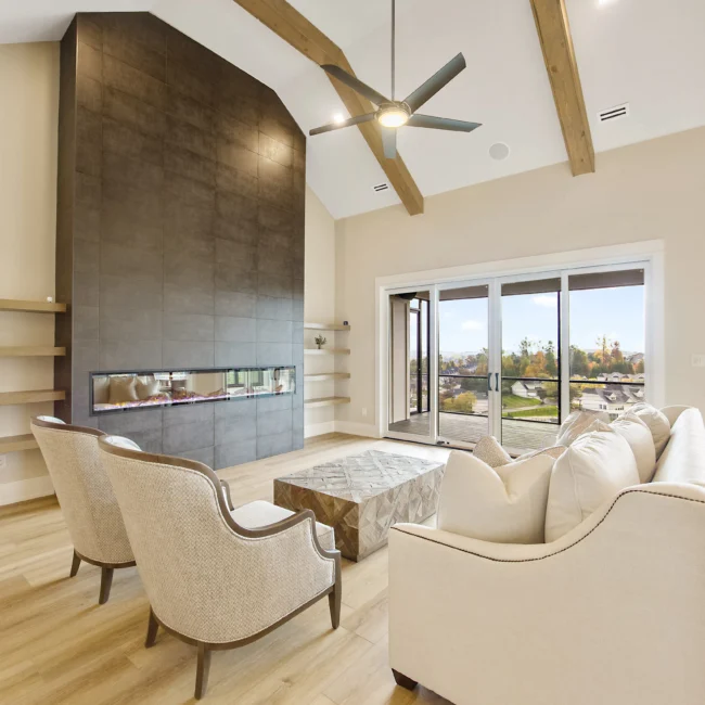 Living room with linear fireplace and tufted chairs in Contemporary Luxury, a custom home by Mike Stevens Homes