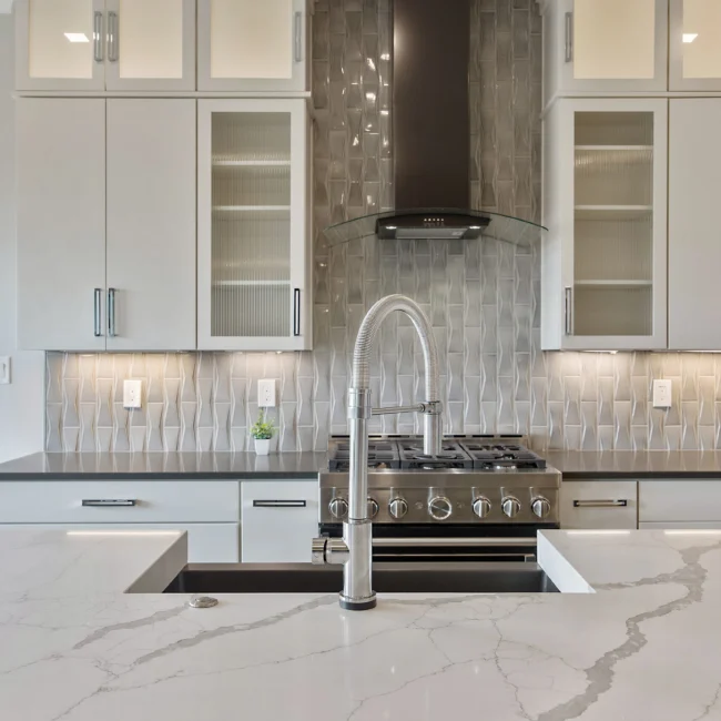 Kitchen with glass-front cabinets and gray tile backsplash in Contemporary Luxury, a custom home by Mike Stevens Homes