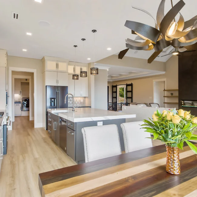 Kitchen island with white stools and wood dining bar in Contemporary Luxury, a custom home by Mike Stevens Homes