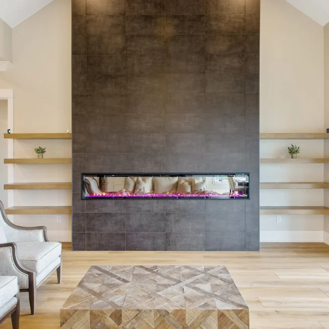 Linear fireplace in dark tile wall with floating shelves in Contemporary Luxury, a custom home by Mike Stevens Homes