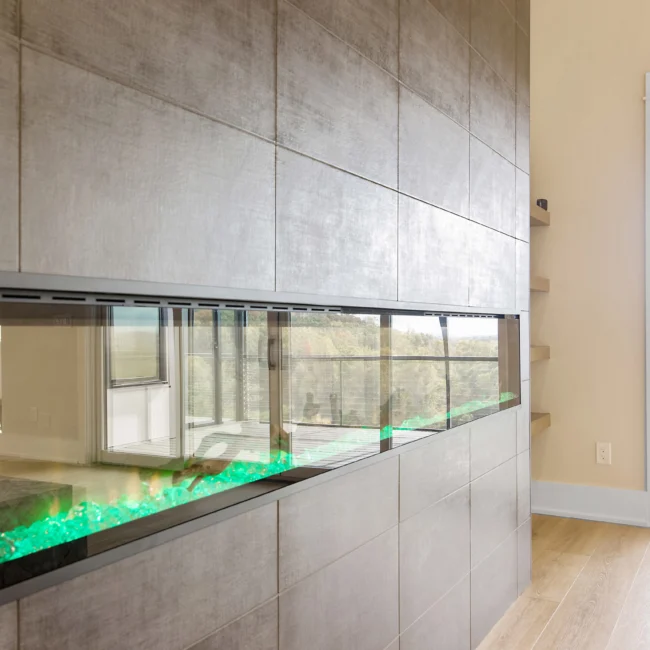 Close-up of linear fireplace with green flame glow in Contemporary Luxury, a custom home by Mike Stevens Homes