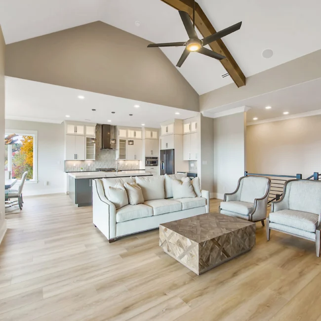 Living room with stone-look coffee table and gray sofa in Contemporary Luxury, a custom home by Mike Stevens Homes