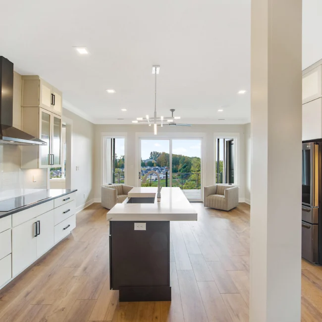 Open kitchen and living room with island and sliders in Contemporary Luxury, a custom home by Mike Stevens Homes