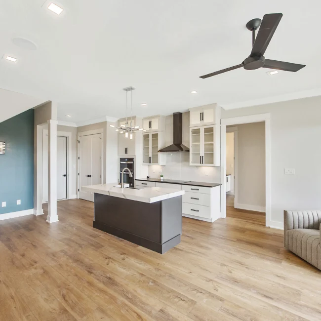 Kitchen with dark island and teal accent wall in Contemporary Luxury, a custom home by Mike Stevens Homes