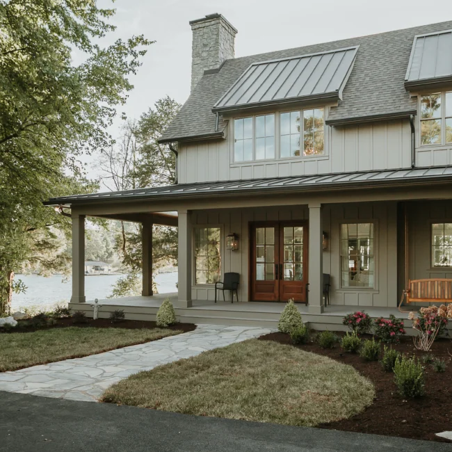 Covered front porch with flagstone walkway and french doors in Island Farmhouse, a custom home by Mike Stevens Homes