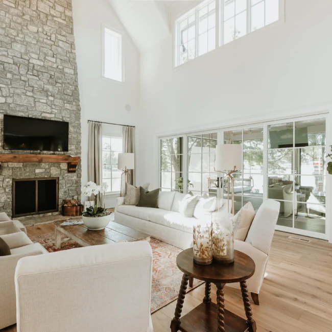 Great room with stone fireplace and vaulted ceiling in Island Farmhouse, a custom home by Mike Stevens Homes