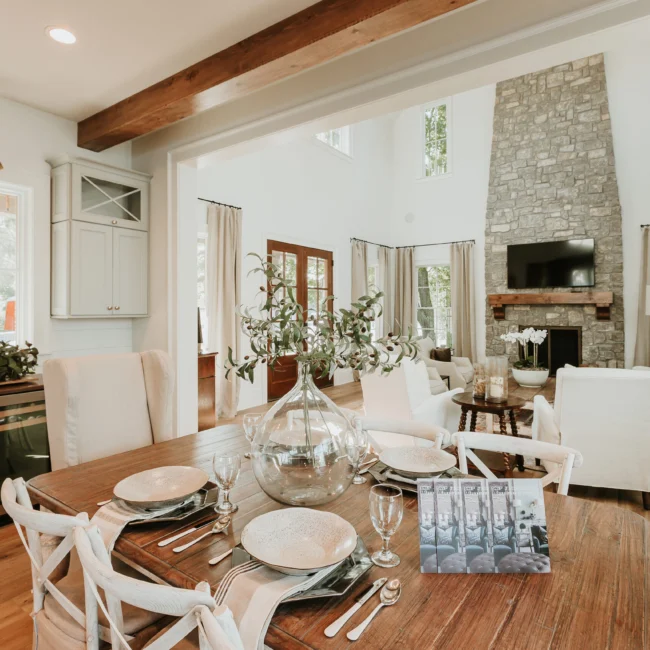 Dining room with stone fireplace and vaulted ceiling in Island Farmhouse, a custom home by Mike Stevens Homes