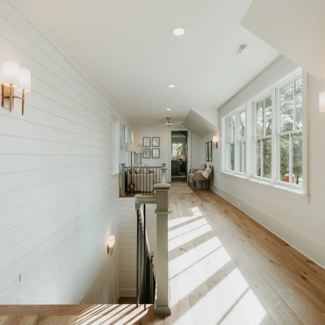 Upstairs hallway with shiplap walls and sunlight in Island Farmhouse, a custom home by Mike Stevens Homes