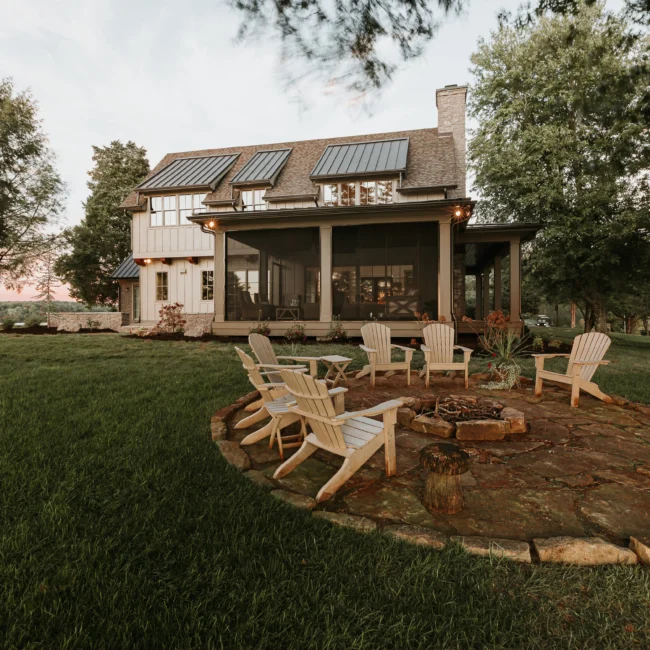 Back patio with fire pit and Adirondack chairs in Island Farmhouse, a custom home by Mike Stevens Homes