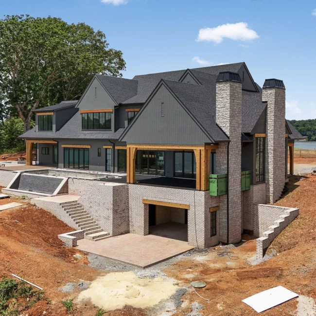 Aerial of brick and stone walk-out exterior under construction in Edgewater Estate, a custom home by Mike Stevens Homes