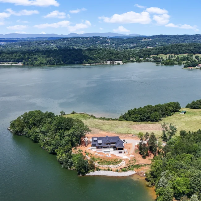 Aerial of lakefront property with home under construction on a point in Edgewater Estate, a custom home by Mike Stevens Homes