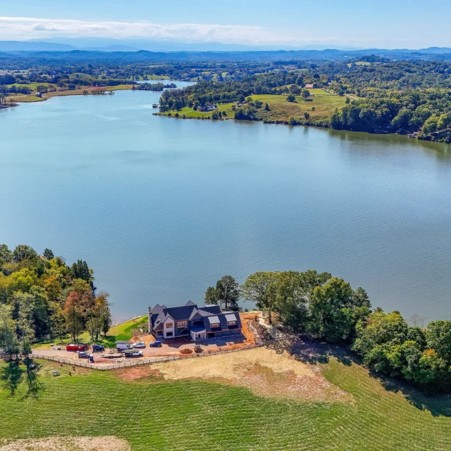 Aerial of lakeside home set on a wooded point in Edgewater Estate, a custom home by Mike Stevens Homes