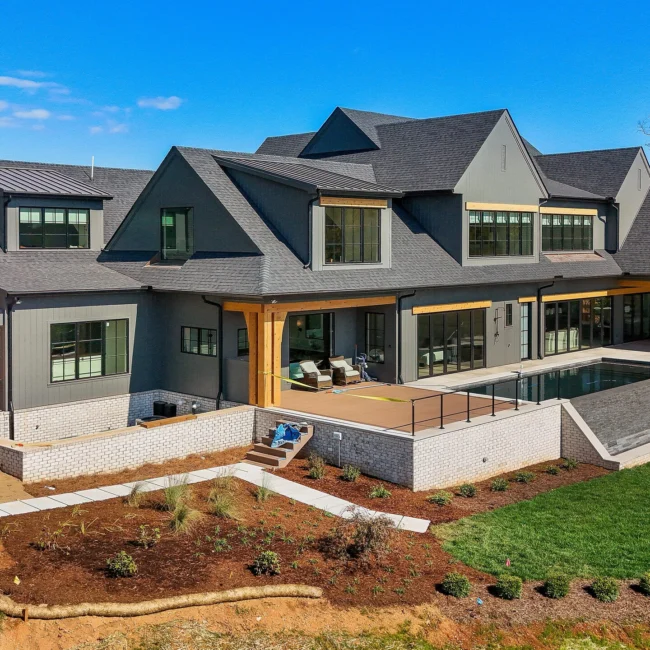 Rear view of home with covered patio, pool and landscaped slope in Edgewater Estate, a custom home by Mike Stevens Homes