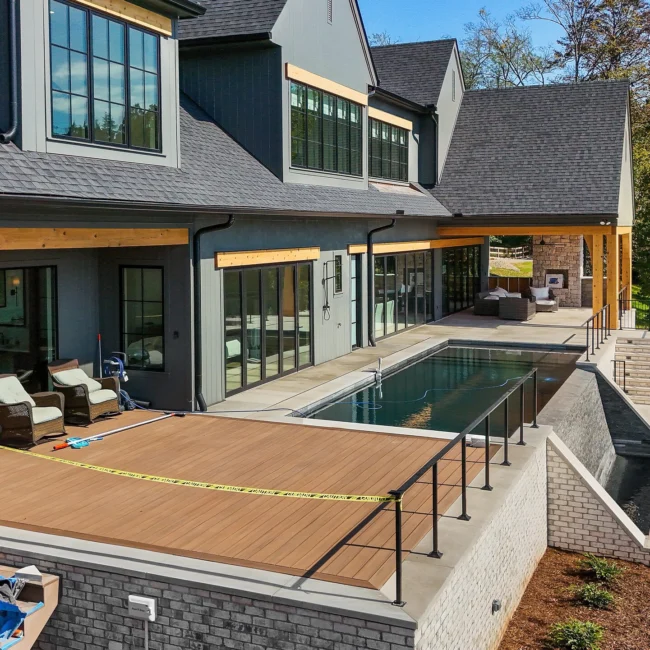 Backyard pool with wood deck, lounge seating and timber accents in Edgewater Estate, a custom home by Mike Stevens Homes
