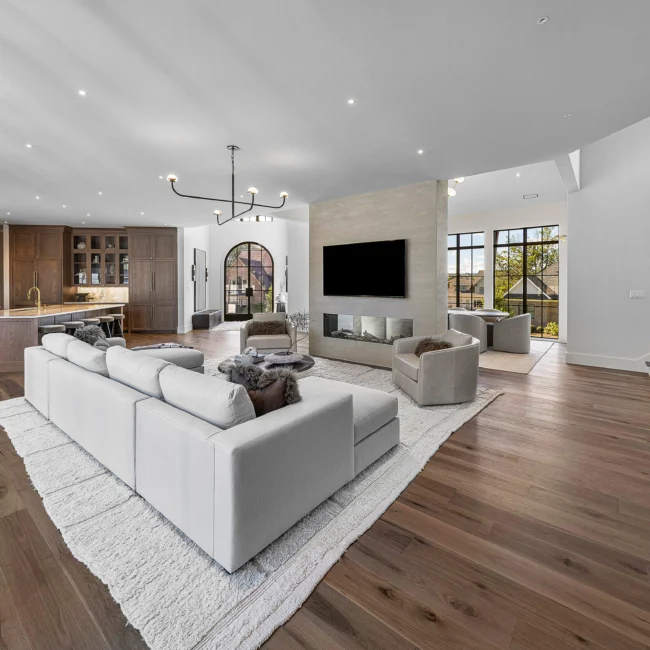 Living room with large sectional sofa, shag rug and arched windows in The Sanctuary, a custom home by Mike Stevens Homes