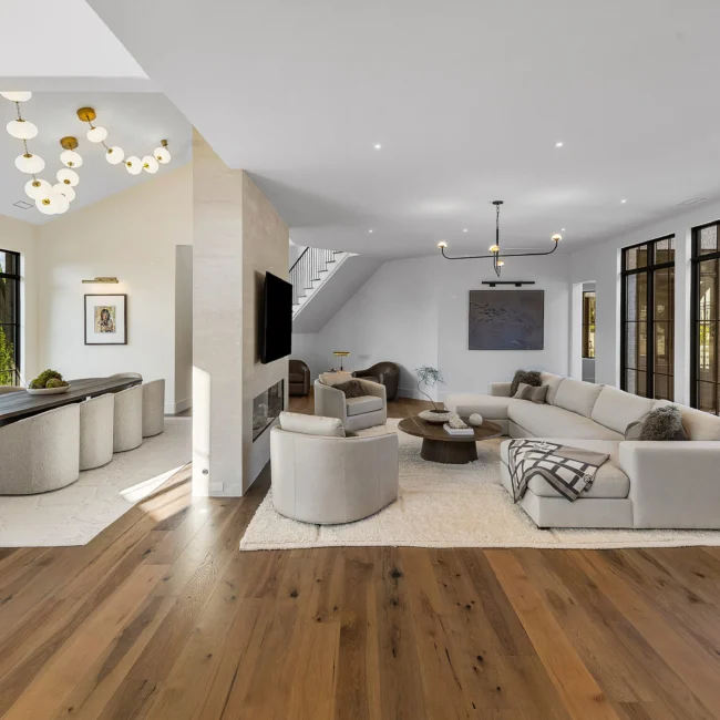 Great room with wood floors, fireplace wall and open stair in The Sanctuary by Mike Stevens Homes