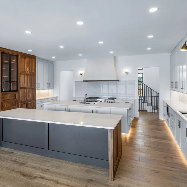 Kitchen with walnut pantry, gray island and under-lit floors in Edgewater Estate, a custom home by Mike Stevens Homes