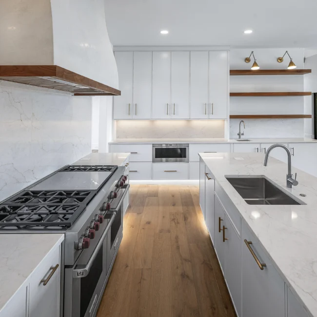 Kitchen with wood vent hood over pro range and open shelving in Edgewater Estate, a custom home by Mike Stevens Homes