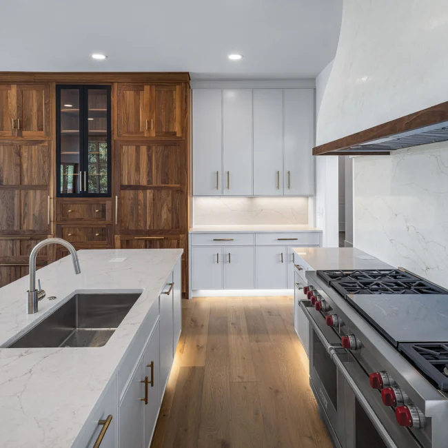 Kitchen with walnut pantry, sink island and pro range in Edgewater Estate, a custom home by Mike Stevens Homes