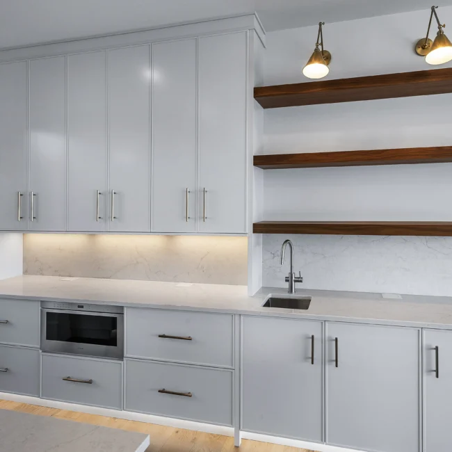 White shaker cabinets with open walnut shelves and microwave drawer in Edgewater Estate, a custom home by Mike Stevens Homes
