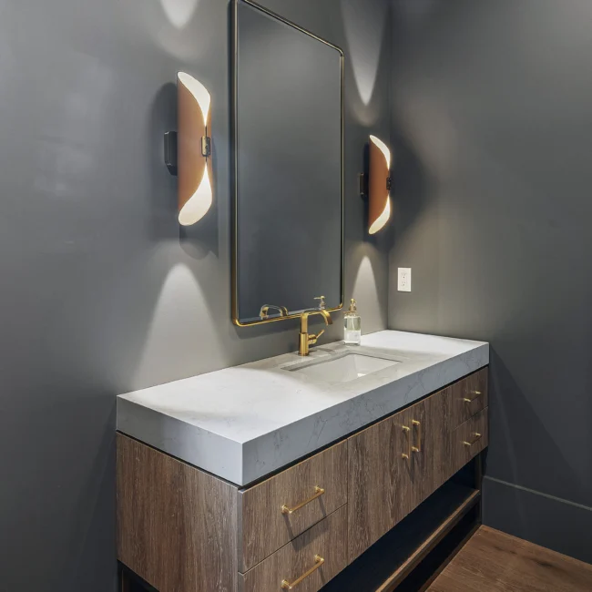 Powder room with walnut vanity, quartz top and brass faucet in Edgewater Estate, a custom home by Mike Stevens Homes