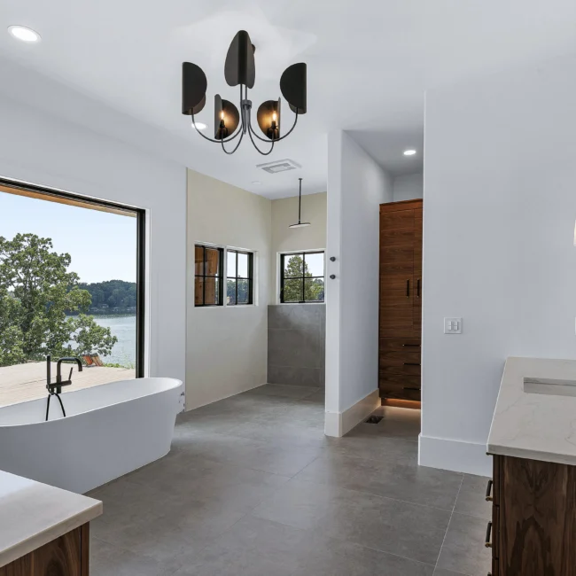 Bath with freestanding tub, lake-view window and walk-in shower in Edgewater Estate, a custom home by Mike Stevens Homes