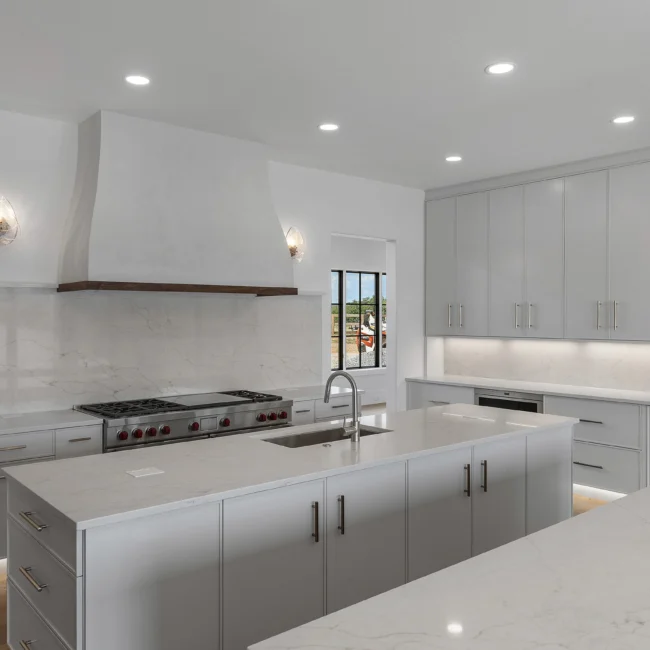 Kitchen with white hood, white cabinets and pro range in Edgewater Estate, a custom home by Mike Stevens Homes