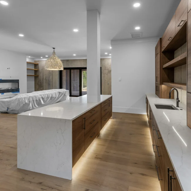 Kitchen with walnut waterfall island and pendant light in Edgewater Estate, a custom home by Mike Stevens Homes