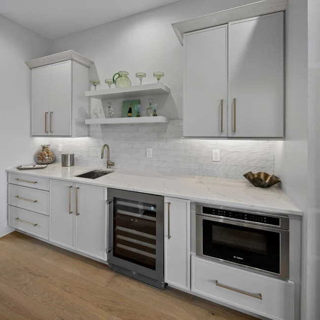 Kitchen with white cabinetry, built-in wine fridge and microwave drawer in The Terrace by Mike Stevens Homes