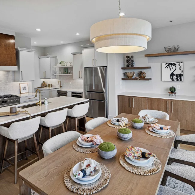 Set dining table with woven chargers and drum pendant in The Terrace by Mike Stevens Homes