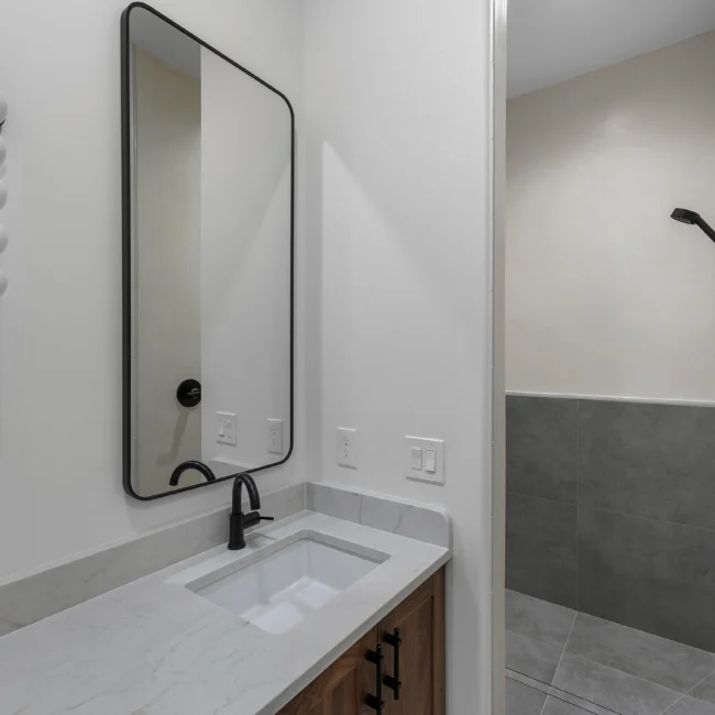 Single vanity with black-framed mirror and undermount sink in Edgewater Estate, a custom home by Mike Stevens Homes