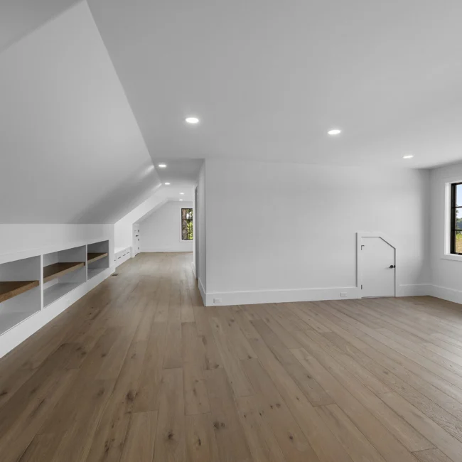 Bonus room with built-in bench seating under sloped ceiling in Edgewater Estate, a custom home by Mike Stevens Homes