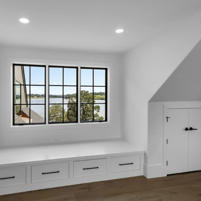 Window seat with drawers beneath black-framed windows in Edgewater Estate, a custom home by Mike Stevens Homes